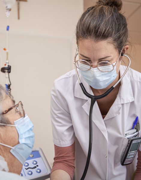 Une médecin penchée sur une patiente dans un environnement hospitalier