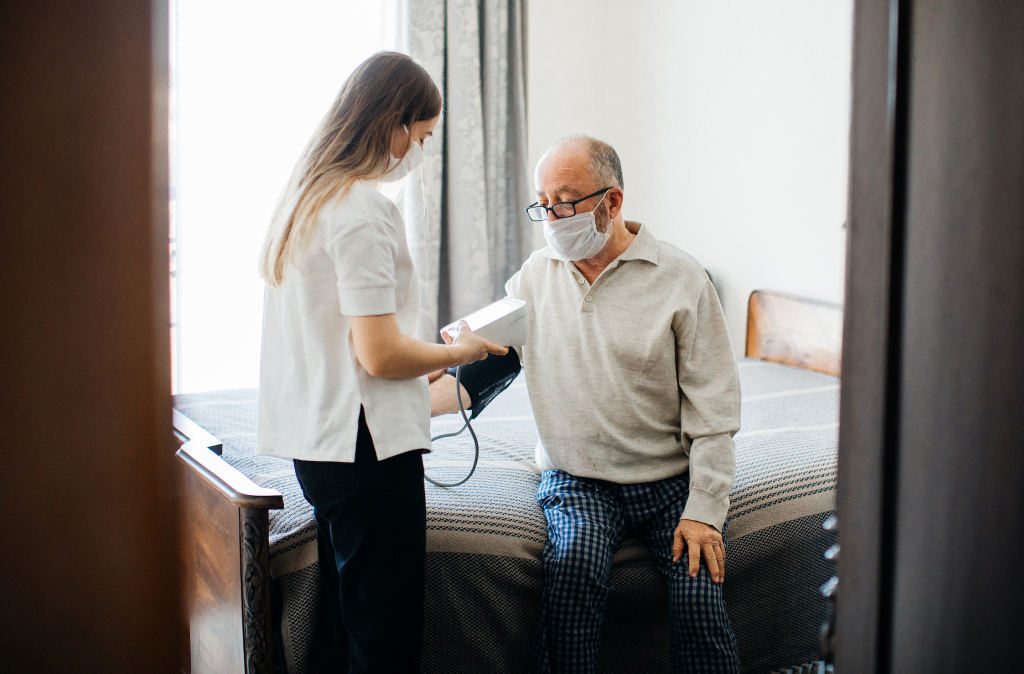 Nurse Visiting Senior Male At Home Doing Blood Pressure Measurement